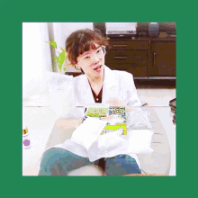 a woman wearing glasses and a lab coat is sitting on a couch holding a bag of beans