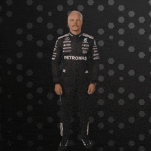a man with a mustache is wearing a petronas racing suit
