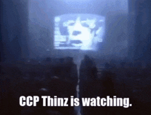a group of people standing in front of a large screen that says ccp thinz is watching