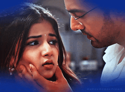 a man touches a woman 's face with a blue background that says avsarcreations on it