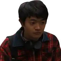 a man wearing headphones and a plaid shirt says " yeah "