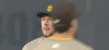 a baseball player wearing a hat with the letter s on it is talking to another baseball player .