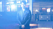 a man in a leather jacket is standing in front of a sign that says 00