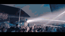 a crowd of people are gathered under a white canopy at a concert