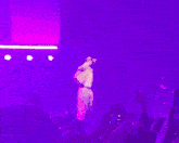 a man is dancing on stage in front of a crowd of people .