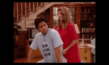 a man wearing a t-shirt that says bun i the wen is sitting next to a woman in a red dress .