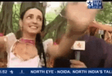 a woman is talking into a microphone on a tv screen that says north eye noida north india 's tall