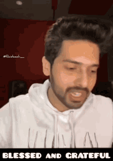 a man with a beard is wearing a white hoodie with the words blessed and grateful on the bottom