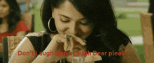 a woman is sitting at a table with the words do n't laugh do n't laugh