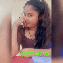 a girl is sitting at a table with the word gayawaya written on the bottom