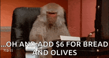 a monkey is sitting at a desk with a briefcase and says oh and add $6 for bread and olives