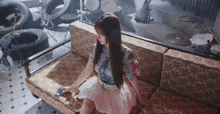 a woman is sitting on a couch in front of a drum set