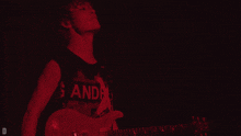 a person playing a guitar with a shirt that says sandman