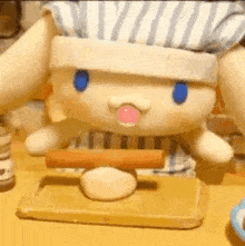 a stuffed animal is sitting on a table with a rolling pin and a rolling pin .
