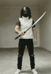 a man wearing a mask holds a sword in his right hand