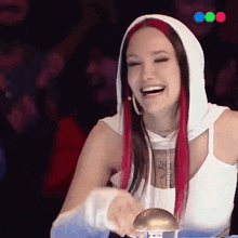 a woman with red hair and a white hoodie laughs