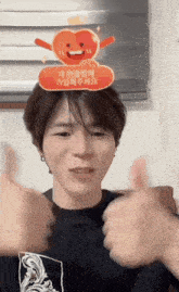a man wearing a heart shaped sticker on his head gives a thumbs up