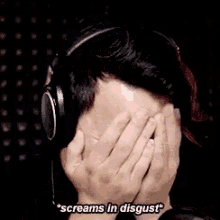 a man is screaming in disgust while another man covers his face .