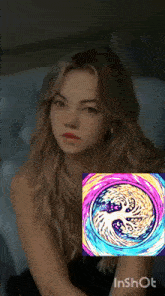 a woman is sitting in front of a painting that says inshot on it
