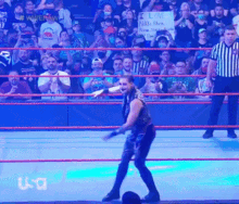 a man in a wrestling ring holds up a sign that says i love nikki black