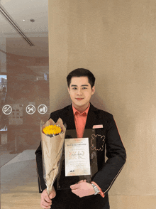 a man holding a bouquet of flowers and a certificate for best metro employee