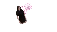 a woman in a black dress is standing in front of a for sale sign