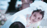a woman in a wedding dress is smiling while being carried by a man