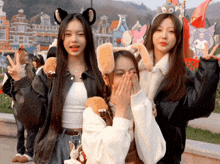 three girls are posing for a picture and one has a hello kitty headband on her head
