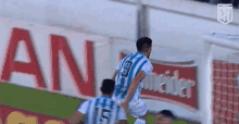 a soccer player wearing a blue and white jersey with the number 9 on it is jumping in the air