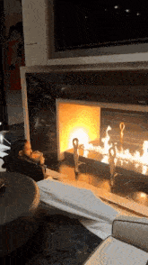 a man sits in front of a fireplace with a statue in front of it