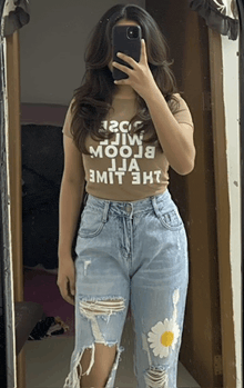 a woman taking a picture of herself in a mirror with a t-shirt that says " mooj "