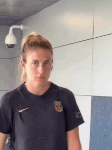 a woman wearing a black nike t-shirt with a fcb logo on it