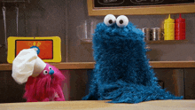elmo and cookie monster are standing next to each other on a table