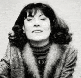 a black and white photo of a woman wearing a fur coat and turtleneck