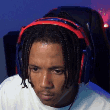 a man with dreadlocks is wearing headphones and making a face