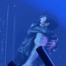 two men are hugging each other in a dark room with blue lights