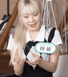a woman with blonde hair has a name tag that says ' 이설 ' on it