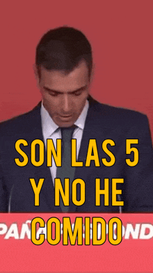 a man in a suit and tie is behind a sign that says son las 5 y no he pancomidond