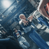 a group of people are dancing in a dark room with a man wearing a shirt that says adidas on it