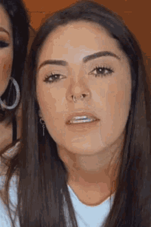 a close up of a woman with a nose ring .