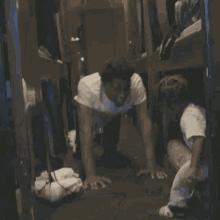 a man in a white shirt is holding another man 's hand while walking down stairs