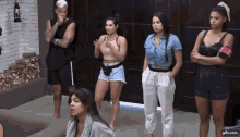 a group of women are standing next to each other in front of a door .