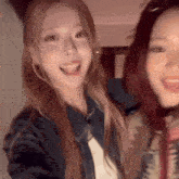 two women are posing for a picture and one is wearing a blue jacket