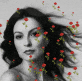 a woman 's face is surrounded by red roses in a black and white photo