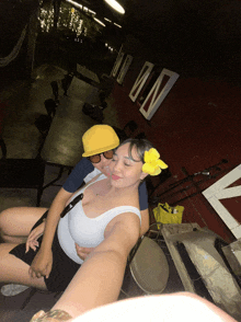 a woman with a yellow flower in her hair takes a selfie