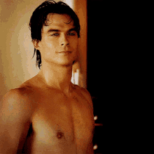 a shirtless man is standing in front of a door looking at the camera .