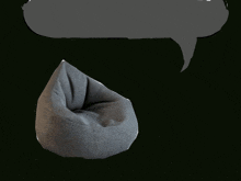 a gray bean bag chair with a speech bubble above it on a black background
