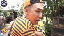 a man wearing an orange hat and an orange and black striped shirt is screaming