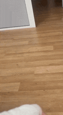 a person 's hand is wrapped in a white bandage while standing on a wooden floor