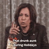 a woman is holding a bottle of whiskey and says that drunk aunt during holidays